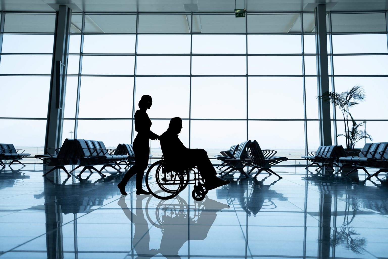 Man in a wheelchair is being taken care at the airport.