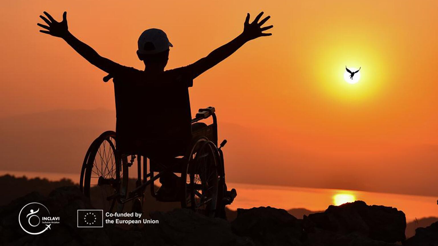 Man sitting in a wheelchair and lifting his hands like antennas while embracing the beautiful sunset in the horizon.